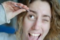 Photograph of a girl plucking her eyebrows with tweezers. Royalty Free Stock Photo