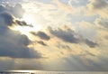 Bright Sunbeams from Golden Yellow Sun Behind Dark Clouds and Spreading over Still Sea Water - Descent of Divine Blessings