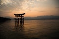 Photograph of the great torii of Miyajima surrounded by water at sunset