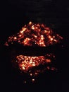 Photograph of a handmade oven filled with glowing embers against the blackness of the night