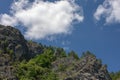 photograph of mountain peaks on clear sunny day. white clouds in blue sky on background Royalty Free Stock Photo