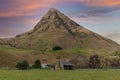 Photograph of an old farm cottage in front of a large hill in New Zealand Royalty Free Stock Photo