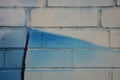 The photograph painted white brick wall with a fragment of graffiti blue with black line