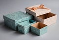 Photograph of patterned gift boxes in teal and beige with geometric designs open and closed soft lighting gray background Royalty Free Stock Photo