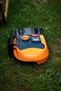 Photograph of a robotic lawn mower, working on the garden