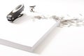 Photograph of some sheets of paper, a stapler, a staple extractor and some paper clips on a white background.The photo has free