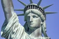 Photograph of the Statue of Liberty holding her torch on a sunny day in Manhattan, known as the lady of New York City.