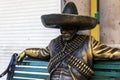 Photograph of a statue of a Mexican sitting on a seat at the door of a souvenir store in the Mexican town of Playa del Carmen