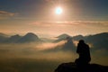 Photograph takes photos of daybreak above heavy misty valley. Landscape view of misty autumn mountain hills and happy man silhoue