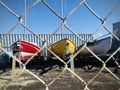 Photograph three different yachts through wire fence.