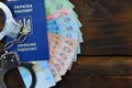 A photograph of a Ukrainian foreign passport, a certain amount of Ukrainian money and police handcuffs. The concept of arresting