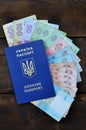 A photograph of a Ukrainian passport and a certain amount of Ukrainian money on a wooden surface. The concept of making money for Royalty Free Stock Photo