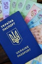 A photograph of a Ukrainian passport and a certain amount of Ukrainian money on a wooden surface. The concept of making money for Royalty Free Stock Photo