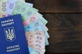 A photograph of a Ukrainian passport and a certain amount of Ukrainian money on a wooden surface. The concept of making money for Royalty Free Stock Photo