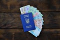 A photograph of a Ukrainian passport and a certain amount of Ukrainian money on a wooden surface. The concept of making money for Royalty Free Stock Photo