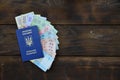 A photograph of a Ukrainian passport and a certain amount of Ukrainian money on a wooden surface. The concept of making money for Royalty Free Stock Photo