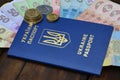 A photograph of a Ukrainian passport and a certain amount of Ukrainian money on a wooden surface. The concept of making money for Royalty Free Stock Photo