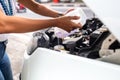 a photograph of an unidentified woman refilling windshield wiper fluid