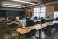 A photograph of an unoccupied classroom filled with empty desks and computers, An empty classroom with rows of computers, Royalty Free Stock Photo