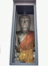 A photograph of view of statue of Buddha from an open door