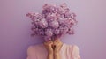 A photograph of a woman holding a bouquet of violet lilacs that cover her face, set against a lavender background. Royalty Free Stock Photo