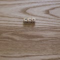 Wooden letters spelling May on a wooden background