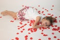 Girl in love lying on a white isolated background on red rose petals Royalty Free Stock Photo