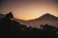 Photographer in action in scenery sunset with high mountain in background and orange colors around -wild active people enjoyin the Royalty Free Stock Photo