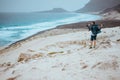 Photographer admitting unique others worldly landscape of sand dunes volcanic cliffs on the Atlantic coast. Baia Das