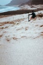 Photographer sitting and admitting bizarre landscape of sand dunes volcanic cliffs on the Atlantic coast. Baia Das Gatas