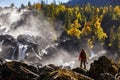 Photographer with backpack enjoying amazing waterfall Travel Lifestyle and success concept vacations into the wild