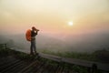 Photographer backpack on the hill taking photo