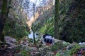 Photographer backpack and river in a mossy lush canyon