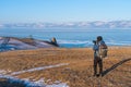 A photographer with backpack talking picture of frozen lake Baikal in winter season, Siberia, Russia Royalty Free Stock Photo