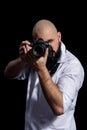 Photographer with camera. Male photographer with beard in a white shirt taking photon over black background