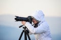 photographer with camera and tripod outdoor taking landscape picture Royalty Free Stock Photo