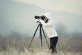 photographer with camera and tripod outdoor taking landscape picture Royalty Free Stock Photo