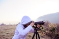 photographer with camera and tripod outdoor taking landscape picture Royalty Free Stock Photo