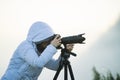 photographer with camera and tripod outdoor taking landscape picture Royalty Free Stock Photo