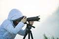 photographer with camera and tripod outdoor taking landscape picture Royalty Free Stock Photo
