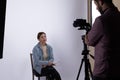 A photographer conducts a photojournalistic interview with a subject in a studio setting Royalty Free Stock Photo
