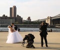 Photographer with the crew shooting newlywed couple under Brooklyn Bridge