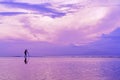 Photographer at dawn taking pictures of the sea. Silhouette of a photographer with a tripod. Silhouette and reflection Royalty Free Stock Photo