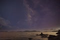 Photographer doing astro photography on the rocks of nightscape