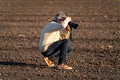 photographer doing his job with plowed land background