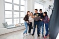 Photographer explaining about the shot to his team in the studio and looking on laptop. Talking to his assistants holding a camera