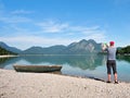 Photographer with eye at viewfinder is taking photo of lake with Alps Royalty Free Stock Photo