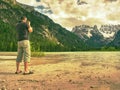 Photographer with eye at viewfinder is taking photo of lake with Alps Royalty Free Stock Photo