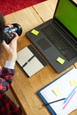 Photographer female working in a creative office holding camera, at desk and retouch photo