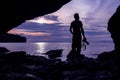 Photographer in front of the cave near the sea. Royalty Free Stock Photo